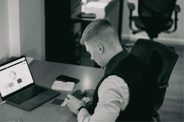 A black and white photograph of James Littlewood sat at his desk